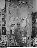 Das beschädigte Plakat nach dem Ende des Zweiten Weltkrieges vor Ruinen, aufgenommen von Richard Peter senior mit dem Hinweis „Litfaßsäule mit der letzten Naziparole überstand den Feuersturm, 1945/1946“; im Besitz der Deutschen Fotothek