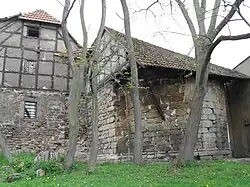 Restmauerwerk der Apsis von St. Wigbert unter einem Ziegeldach aus späterer Zeit