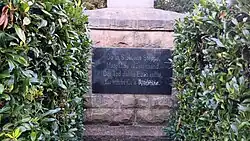 Eine metallene Plakette auf einem Sockel. Darauf die Aufschrift: Ob in Sibiriens Steppe, Marokkos Wüstensand. Der Tod dahin Euch raffte, Ihr starbt für's Vaterland.