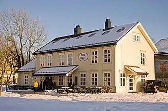 Foto eines weißen Holzgebäudes in verschneiter Umgebung