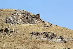 Reliefwand mit anschließender Zyklopenmauer, im Vordergrund weitere Mauerfragmente