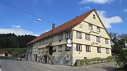 verschindelter Satteldachbau, zweistöckig, aus dem 18. Jahrhundert, an Straße, Gelb bemalt