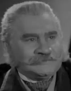 Gesicht einer männlichen Person in den 50er Jahren von vorne nach rechts schauend in schwarzweiß.