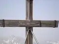 Das Gipfelkreuz des Hohen Bretts, im Hintergrund der Hochkalter (2608&nbsp;m).