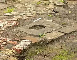 Bearbeiteter Fundamentstein für eine Holzkonstruktion innerhalb des Rauchgaskegels