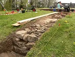 Freigelegte Bruchsteine am Rande des Grashügels
