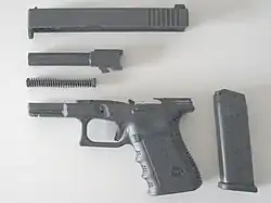 Verriegelungsblock auf dem Lauf greift in das Auswurffenster des Schlittens ein; Verschlusssteuerung erfolgt über unten am Lauf befindliche Steuerkurve (Nase)