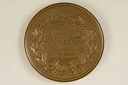 Die Rückseite der bronzenen Graefe-Medaille zeigt sieben zentrierten geprägte Zeilen jeweils in Versalschrift: „HERMANNO“, „DE • HELMHOLTZ“, „D • D“, „SOCIETES“, „OPTHALMOLOGICA“, „HEIDELBERGAE“, „A • MDCCCLXXXVI“. Der Schriftblock wird durch ein Lorbeerkranz gerahmt. Oben am Rand sind die beiden Worte „PRAEMIVM“ „GRAEFIANVM“ wiederum Versalschrift eingeprägt