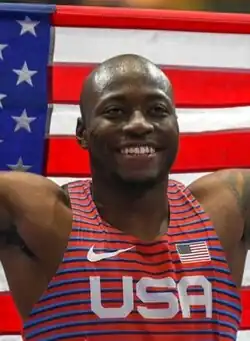 Der Weltmeister über 110 Meter Hürden Grant&nbsp;Holloway mit Fahne und strahlendem Gesicht