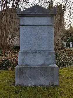 Das Bild zeigt einen großen Grabstein aus hellem Stein.