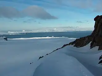 Blick von der Livingston-Insel in der Umgebung des Ravda Peak über die McFarlane Strait hinweg auf den Greaves Peak (Hintergrund, links) zwischen dem Duff Point und den Crutch Peaks