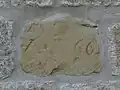 Grundstein des Pfarrhauses mit der Inschrift 1666 (was auch als halbe 8 zu lesen wäre, dann 1444)