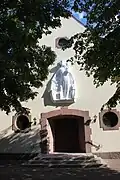 Schutzmantelmadonna von Gisela Bär über dem Portal der Kirche