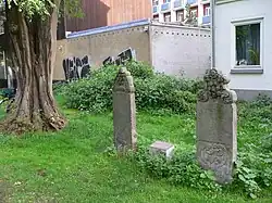 Grabsteine von Hammet und Hasan mit der durch das Türkische Generalkonsulat im Jahr 2000 gesetzten Grabplatte in türkischer und deutscher Sprache