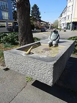 Der «Ranzen Edi» sitzt auf dem Brunnenrand und lässt, mit aufgekrempelten Hosenbeinen, seine Füsse und Unterschenkel ins Wasser baumeln. Der Kragen ist absichtlich so hoch, um zu verhindern, dass bei Wind Wasser daneben spritzen könnte. Das Wasser gelangt durch die Füsse von «Ranzen Edi» wieder in den Trog zurück. Seit einigen Jahren ist der Wasserdruck nicht mehr genug stark, als dass der Wasserstrahl bis in den Mund von «Ranzen Edi» reicht.