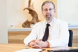 Prof. Dr. Hans Moises hinterm Schreibtisch, Foto von 2015