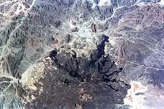 Satellitenbild von Medina und dem südlich davon befindlichen Lavafeld. Die Talsenke von Medina, die zum Haram (heiligen Bezirk) erklärt wurde, befindet sich im oberen Teil des Bildes