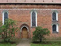 Nordwand mit Konsölchenfries und Spitzbogenportal