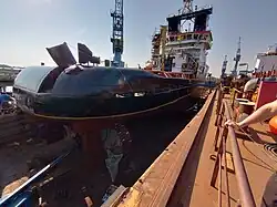 Heckansicht der Nordic im Trockendock. Der weiße Schriftzug Nordic am Heck ist wegen der Lackierarbeiten noch überklebt