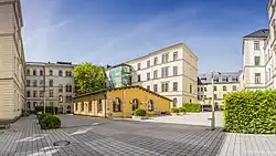 Kleines flaches Gebäude im Innenhof eines großen Gebäudes.