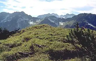 Vorderer Wildgundkopf (höchster Gipfel im linken Bildbereich) vom Älpelekopf. Am linken Bildrand der Hintere Wildgundkopf. Ganz rechts der Himmelschrofen. Im hinteren Kamm links die Schafalpenkopfgruppe und rechts die Oberstdorfer Hammerspitze[1]