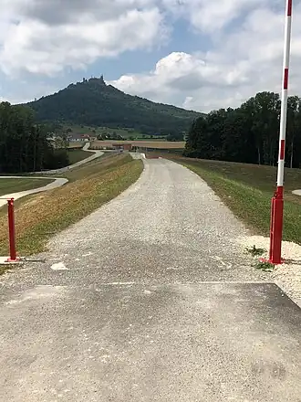 Damm (Nordansicht), der Staubereich liegt links, im Hintergrund die Burg Hohenzollern