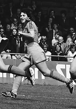 Das Schwarzweiß-Foto zeigt Toos Bax im Lauf, den Hockeyschläger in der Hand.