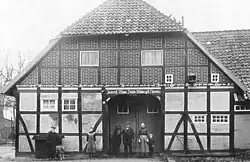 Der Schaugiebel des Hallenhauses von Hof Burzlaff mit Bewohnern, 1920