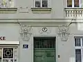 Tor von Nr. 104 (secessionistisch) in der Hollergasse mit dreiteiligen Mädchenmasken