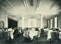 Speisesaal. Links der Durchgang zum Tanzsaal, verborgen durch den vorgezogenen Vorhang.