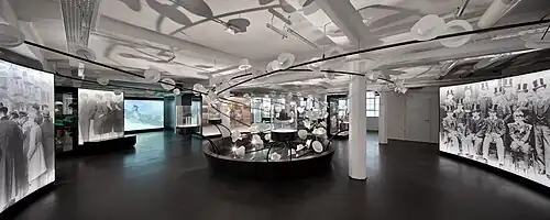 Innenaufnahme des Hutmuseums. Mehrere weiße Hüte scheinen durch die Luft zu schweben.