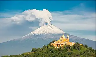 Der Popocatépetl mit der Kirche von Cholula im Vordergrund