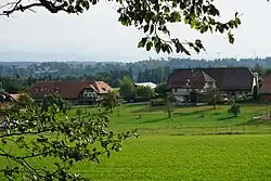 Häuser eines kleinen Bauerndorfes, davor Felder