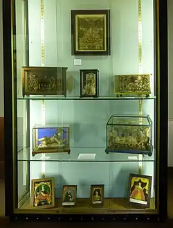 Blick in einen Schaukasten: Hinterglasbilder und Wachsstatuetten