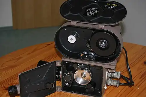 Innerer Aufbau einer Hitachi 16HM, deut­lich ist das silberglänzende Transport­zahnrad hinter dem Objektiv zu erkennen