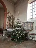 Innenansicht mit Blick zum Taufbecken, dem rechtem Seitenaltar, zur Kanzel und zum Weihnachtsbaum