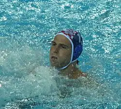 Buljubašić ist im Wasser, erkennbar sind nur der Kopf und die Badekappe mit der Nummer 13.