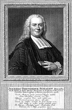 Das Bild zeigt ein Porträt von einem lächelnden, lockigen Mann, der in seiner linken Hand ein kleines Buch hält.