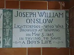 A tablet formed of six standard sized tiles, bordered by green flowers in the style of the Arts and Crafts movement