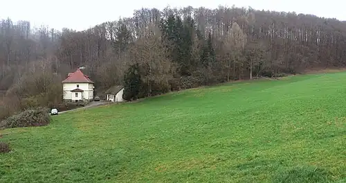 Früherer Standort des Lagers auf einer Wiese mit Wohnhaus, in dem der SS-Lagerführer 1944 und 1945 lebte