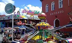 Das Bild zeigt die Fahrgeschäfte „Cortina Jet“ und „Super Jet“ vor dem Rathaus