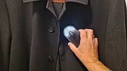 Kaltplasmagerät zur Geruchsentfernung von Textilien bei der Anwendung auf einem Mantel