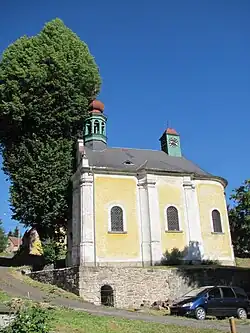 Denkmalgeschützte St.-Vitus-Kapelle in Dražov, Stanovice, gelb gestrichen mit weißen Säulen und zwei grünen Türmchen