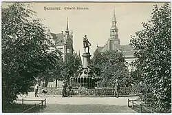Um 1900: Der Gutenberg-Brunnen gegenüber der Ebhardtstraße in der Friedrichstraße (heute Friedrichswall); im Hintergrund die Aegidienkirche