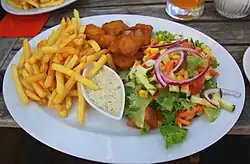 Kibbeling (Mitte, oben) mit Pommes frites, Remoulade, buntem Salat