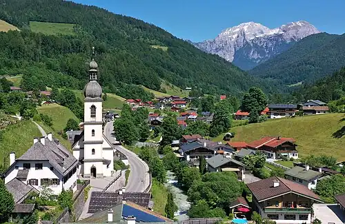 Pfarrkirche St. Sebastian mit Pfarrhof, im Hintergrund Hoher Göll