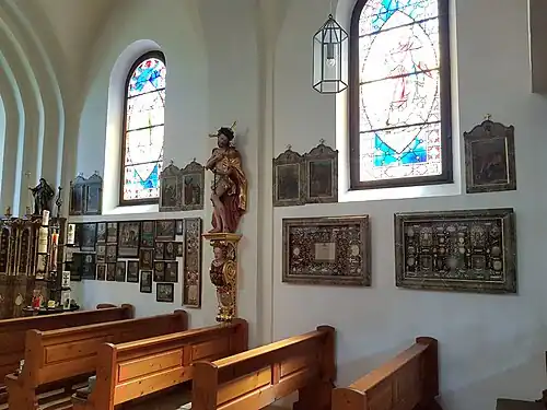 Wand mit Votivtafeln und einem Geißelheiland