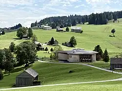 Ansicht von Westen. Die Holzkonstruktion ist mit Schindeln aus heimischer Fichte und Lärche eingekleidet.