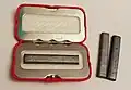 Unbenutzter Kohle-Taschenofen, daneben zwei Kohlestäbchen