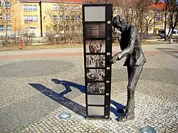 Komeda-Skulptur in Poznań (Posen), Szenen aus Filmen mit seiner Musik betrachtend, heute vor dem Kongress- und Lehrzentrum der Medizinischen Universität